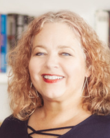 Professional headshot of Antoinette Coetzee, smiling warmly in an indoor setting.