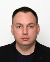Formal headshot of Bojan Smudja in a black blazer in front of a white background.